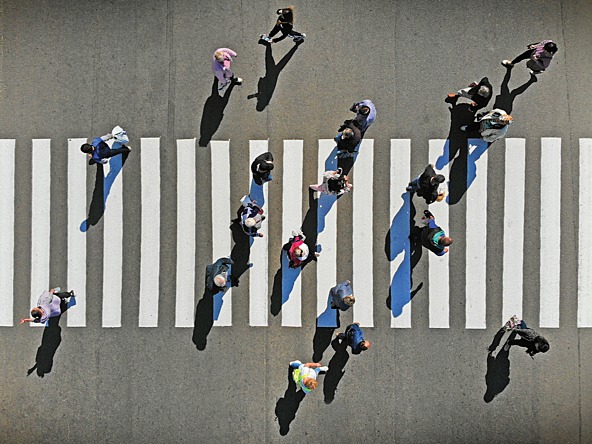 Aerial view of people walking across a zebra crossing  